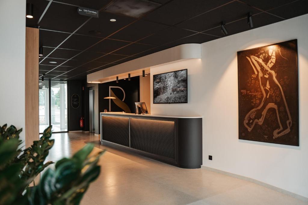 a lobby with a reception desk and paintings on the wall at Roannay - Francorchamps in Francorchamps