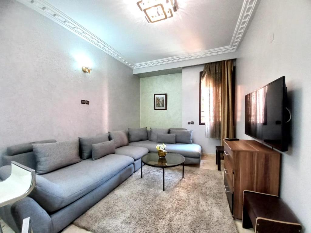 Una sala de estar con un sofá y un televisor en Central Aparts Av Prince Moulay Abdellah, en Marrakech