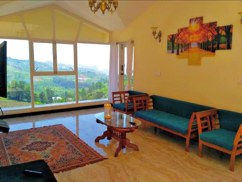 ein Wohnzimmer mit einem Sofa, Stühlen und einem Tisch in der Unterkunft Mysterious mountain in Udagamandalam