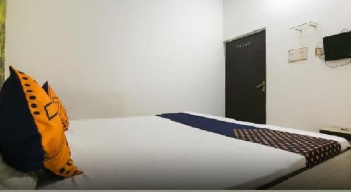 a bedroom with a white bed with a butterfly pillow at Hotel Classic Gold By WB Inn in Agra