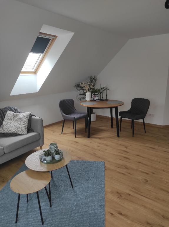 un soggiorno con due tavoli e un divano di Ferienwohnung Im Distelweg a Scheid