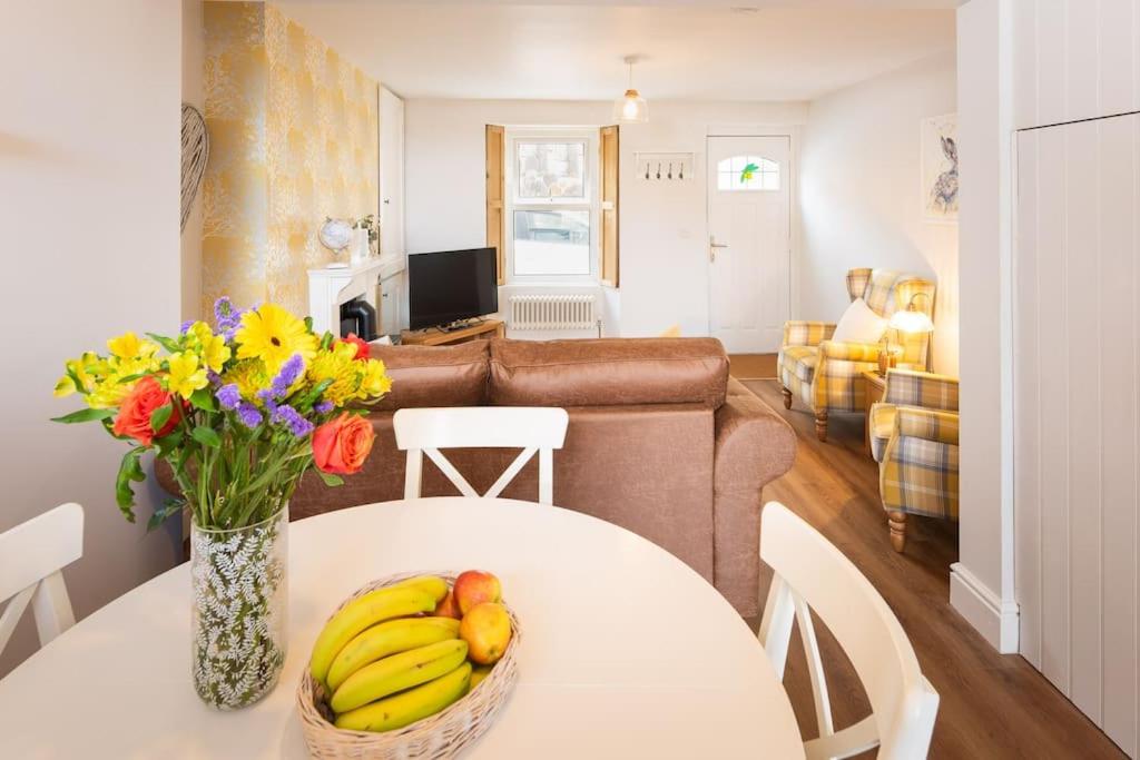 a living room with a table with bananas and flowers on it at *Brand New* Olive Grove Cottage in Torquay