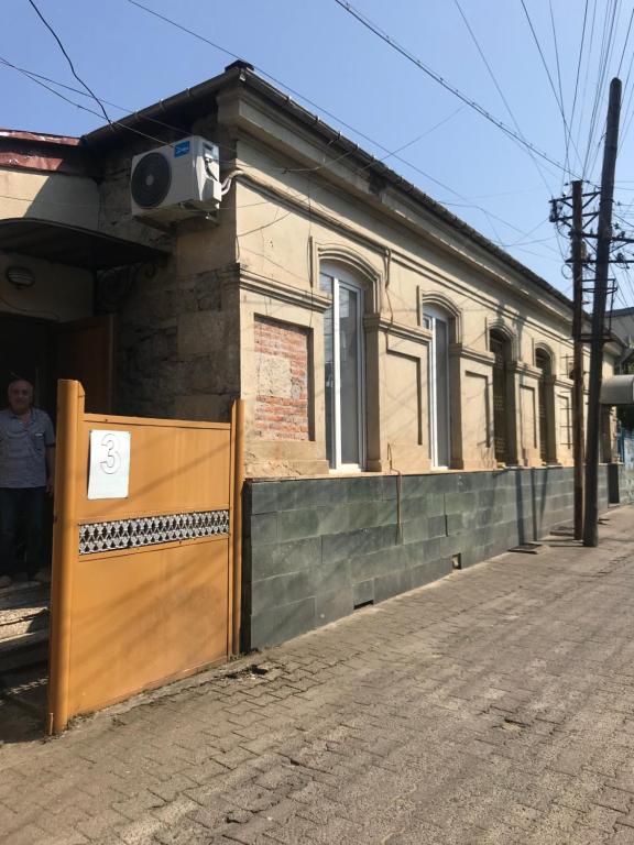 un edificio con una puerta de madera delante de él en ЦЕНТР ГОРОДА СПОКОЙНАЯ УЛИЦА, en Kutaisi