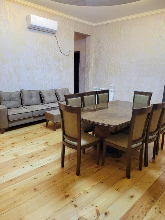 a dining room with a table and chairs and a couch at guest house TSVARA in Vani