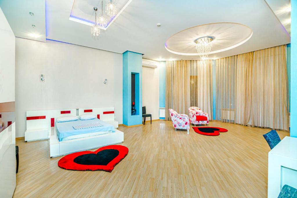 NIzami Street 4 Room DeLuxe في باكو: غرفة نوم بسريرين ووسائد حمراء على الأرض