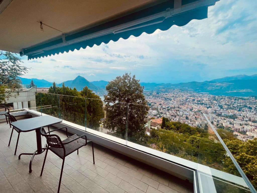 balcón con mesa, sillas y vistas en Appartamenti da sogno en Lugano