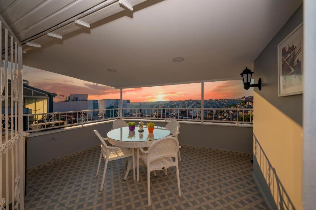 a balcony with a table and chairs and a sunset at Taxim Trend Suites in Istanbul