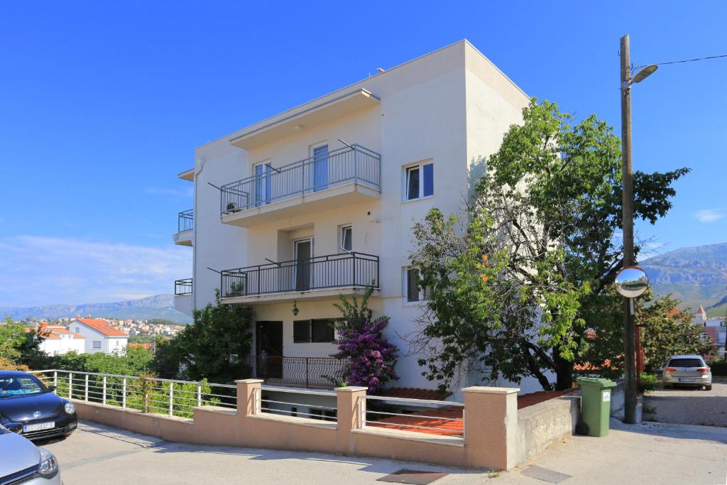 a white building with balconies on the side of it at Apartments by the sea Podstrana, Split - 9714 in Podstrana