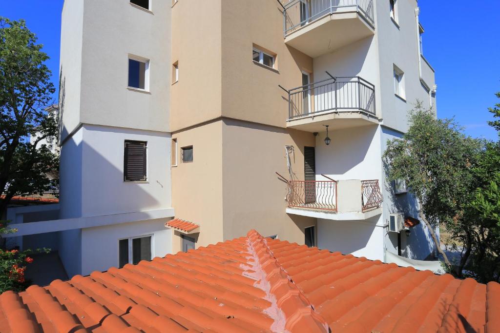 an apartment building with a red tile roof at Apartments by the sea Podstrana, Split - 9714 in Podstrana