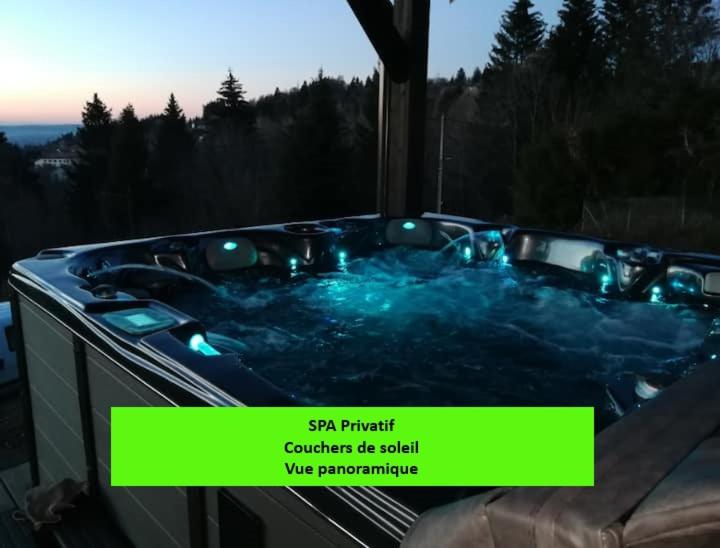 een bubbelbad met verlichting en een bord met de tekst "blijf Finch" bij Chalet neuf avec jacuzzi privé, vue imprenable sur Massif des Vosges in Belfahy