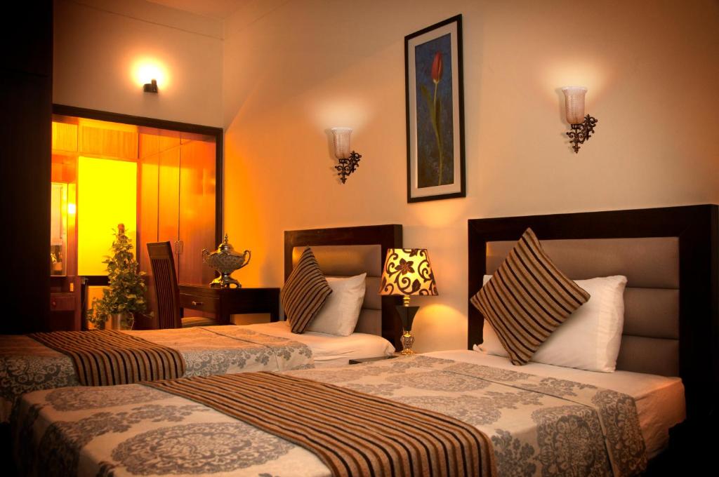 um quarto de hotel com duas camas em Royal Elegance Hotel em Lahore