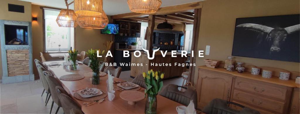 B&B La Bouverie HF في وايمس: غرفة طعام مع طاولة مع كراسي وتلفزيون