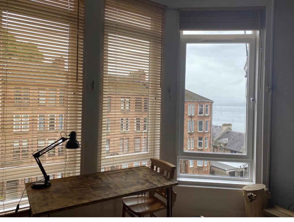 a desk in a room with two large windows at Lovely 2 Bedroom with Riverside Views Pet Friendly in Gourock