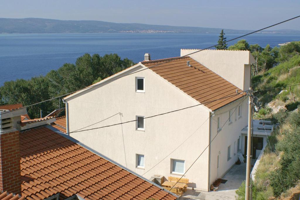 a large white building with a view of the water at Apartments by the sea Duce, Omis - 2829 in Duće