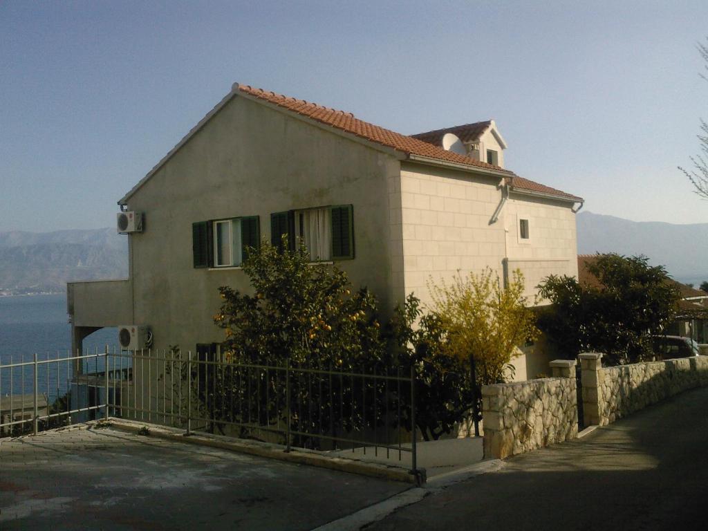 une maison avec une clôture devant elle dans l'établissement Apartments with a parking space Postira, Brac - 2911, à Postira