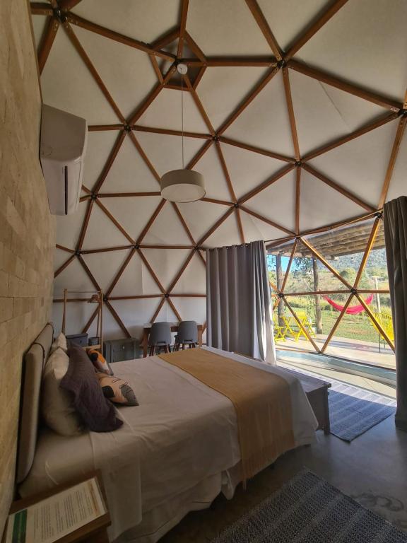 a bedroom with a bed in a large tent at Domo da Cuesta - Glamping com vista para a montanha in Bofete