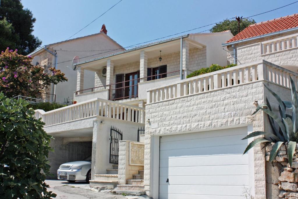 a white house with a garage and a car at Apartments with a parking space Sutivan, Brac - 2846 in Sutivan