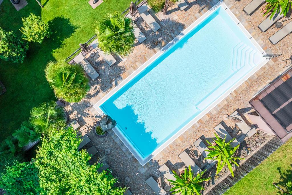 an overhead view of a swimming pool with palm trees at Hotel Christine in Gargazzone
