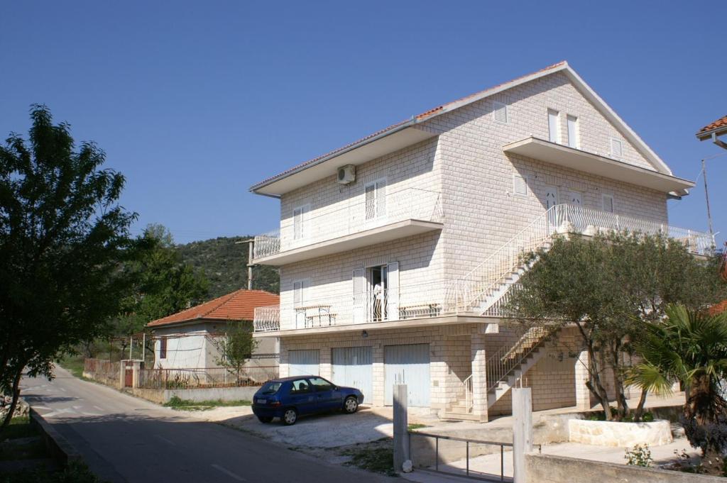 a house with a car parked in front of it at Apartments with a parking space Vinisce, Trogir - 2987 in Vinišće