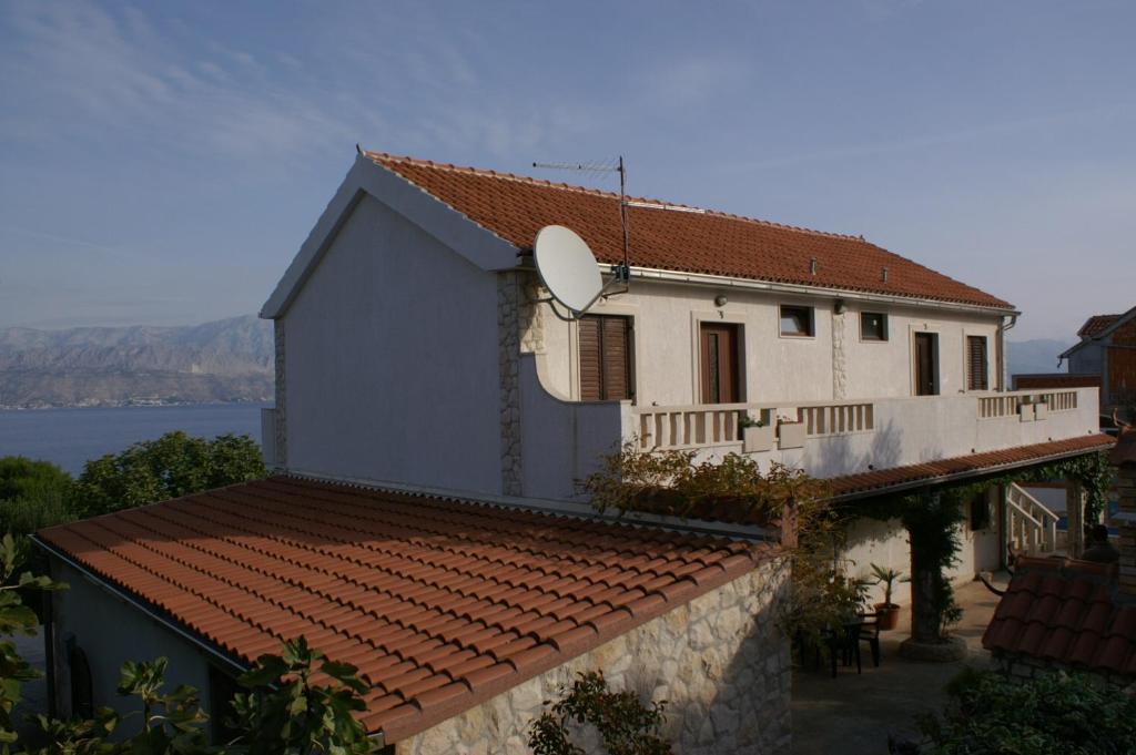 a white house with a red roof and a lake at Apartments with a swimming pool Splitska, Brac - 2889 in Splitska