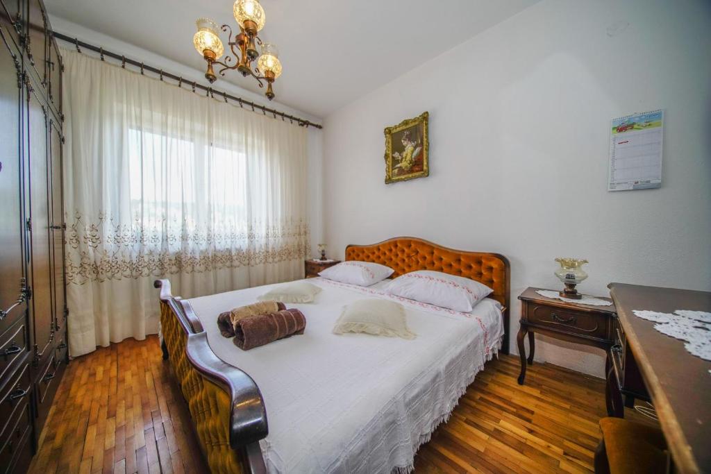 een slaapkamer met een groot bed met witte lakens bij Apartments with a parking space Splitska, Brac - 2857 in Supetar