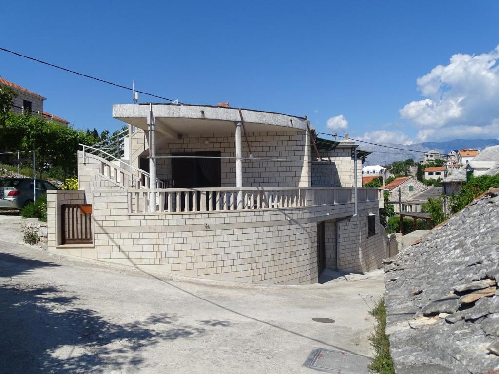 a brick house with a gate and a wall at Apartments by the sea Sumartin, Brac - 2951 in Sumartin