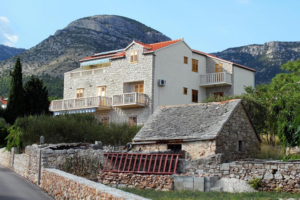 a large white house with a stone wall at Apartments with a parking space Bol, Brac - 2900 in Bol
