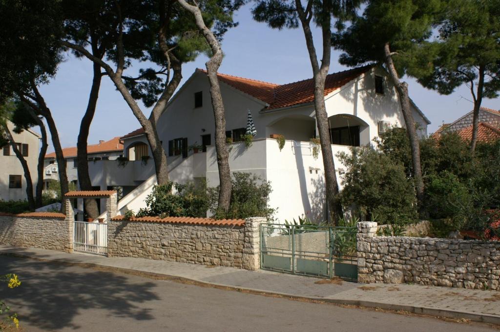 蘇佩塔爾的住宿－Apartments by the sea Mirca, Brac - 2902，白色的房子,有栅栏和树木
