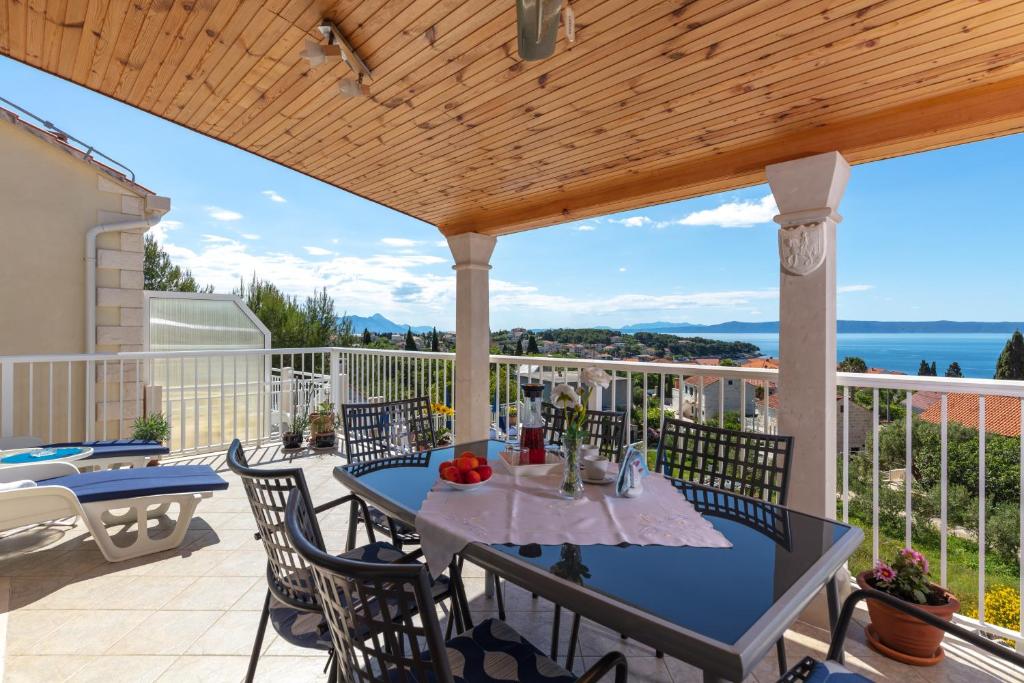 a patio with a table and chairs on a deck at Apartments by the sea Sumartin, Brac - 2940 in Sumartin