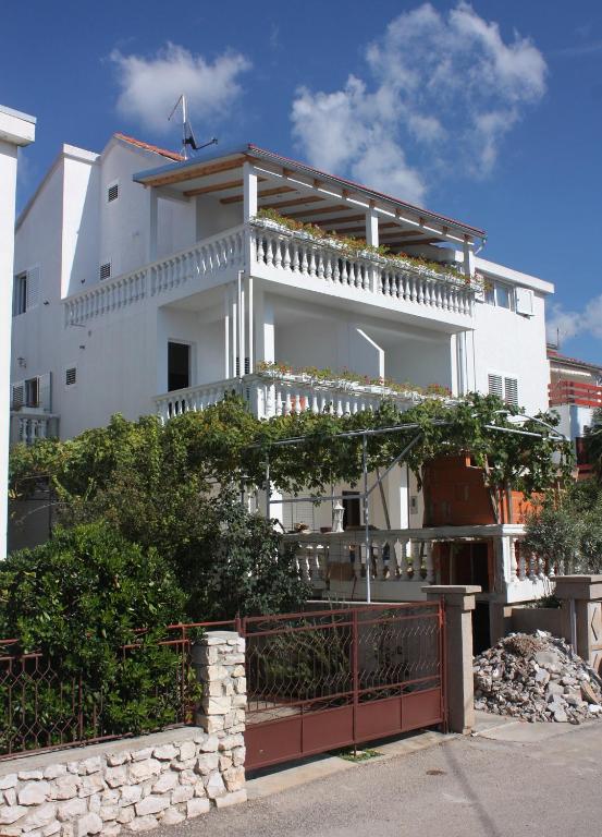 a white building with a fence in front of it at Apartments with parking space Vodice - 2995 in Vodice