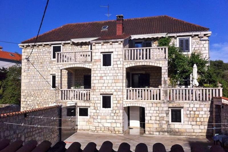 a stone house with a balcony on top of it at Apartments by the sea Sutivan, Brac - 2946 in Sutivan