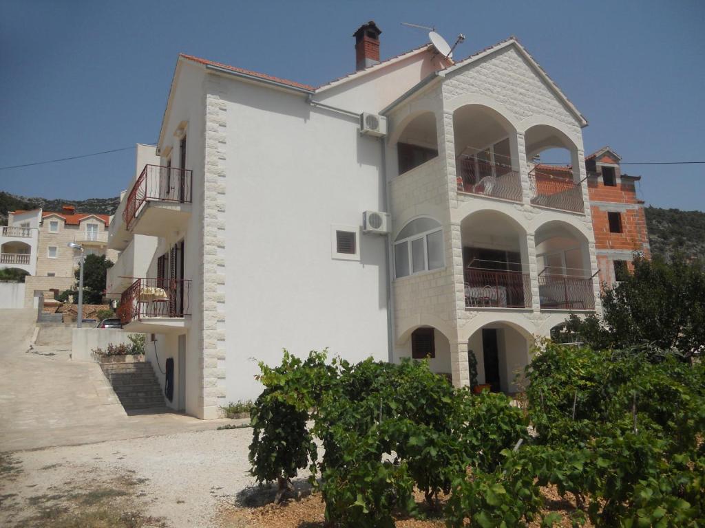 a white building with balconies on the side of it at Apartments with a parking space Bol, Brac - 2890 in Bol