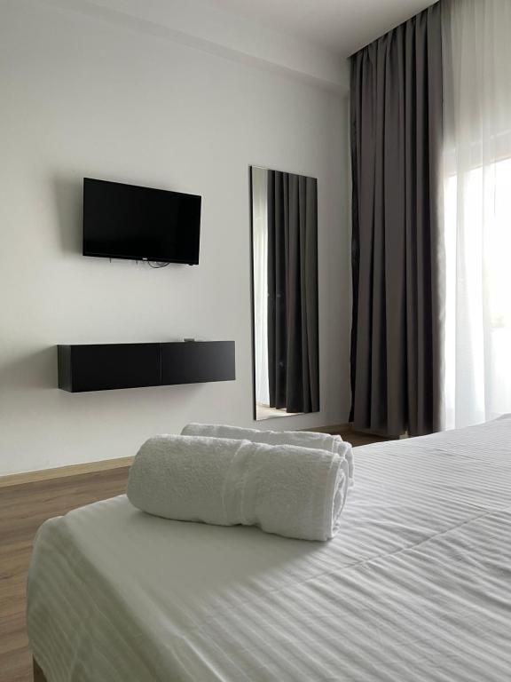 un letto bianco con un asciugamano sopra di Ladi Rooms a Tirana