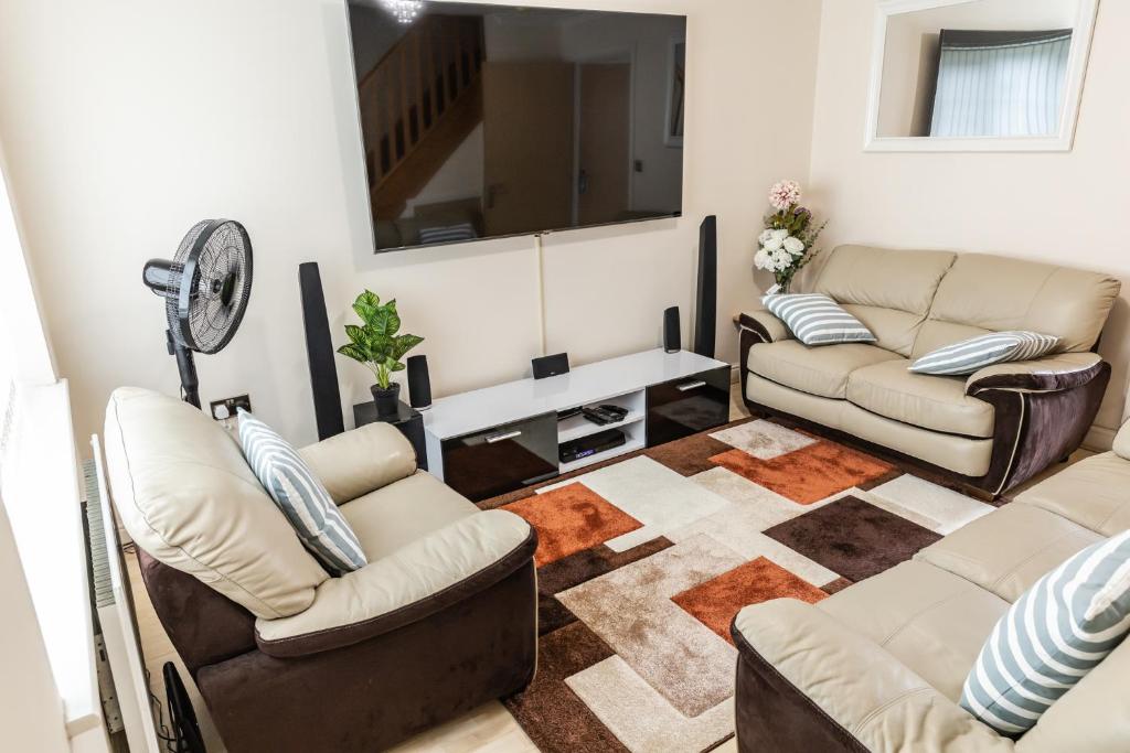sala de estar con 3 sofás y TV en Resource Homes, en Bradshaw