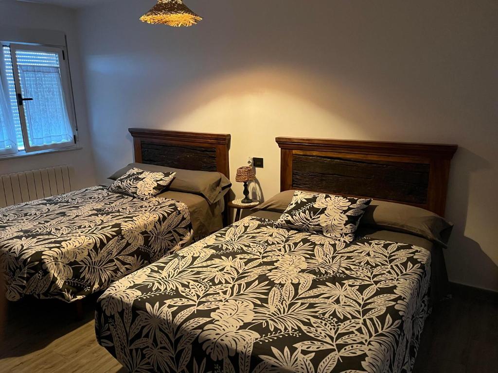 a bedroom with two beds and a lamp at Grande y precioso Ático acogedor in Montejo
