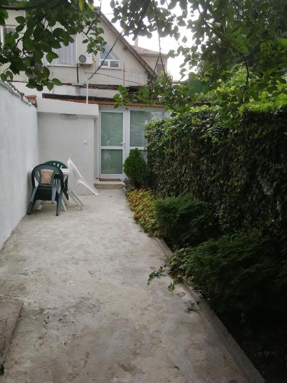 a patio with a bench in front of a house at Studio Rayskata yabalka in Varna City