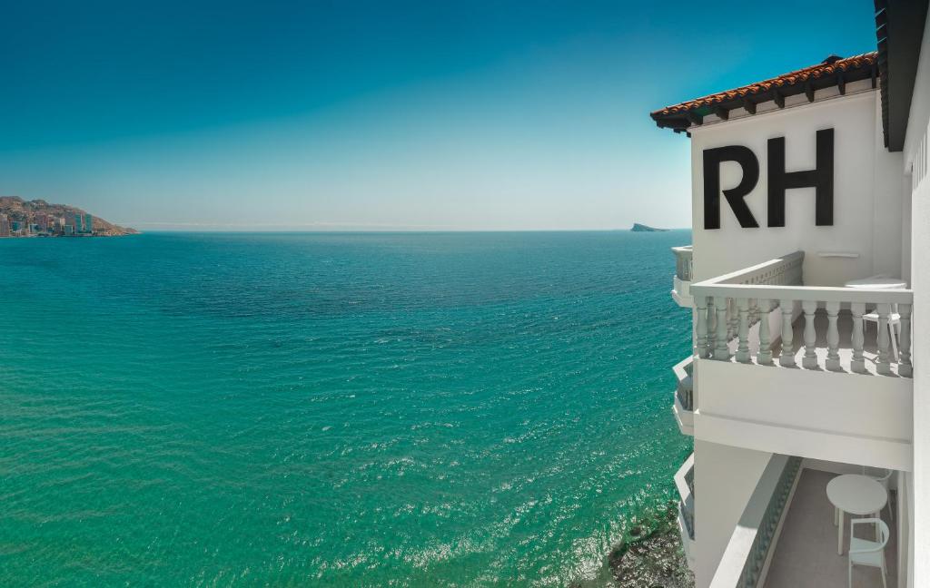 a building with a rtk sign on it next to the ocean at Gastrohotel Boutique RH Canfali in Benidorm