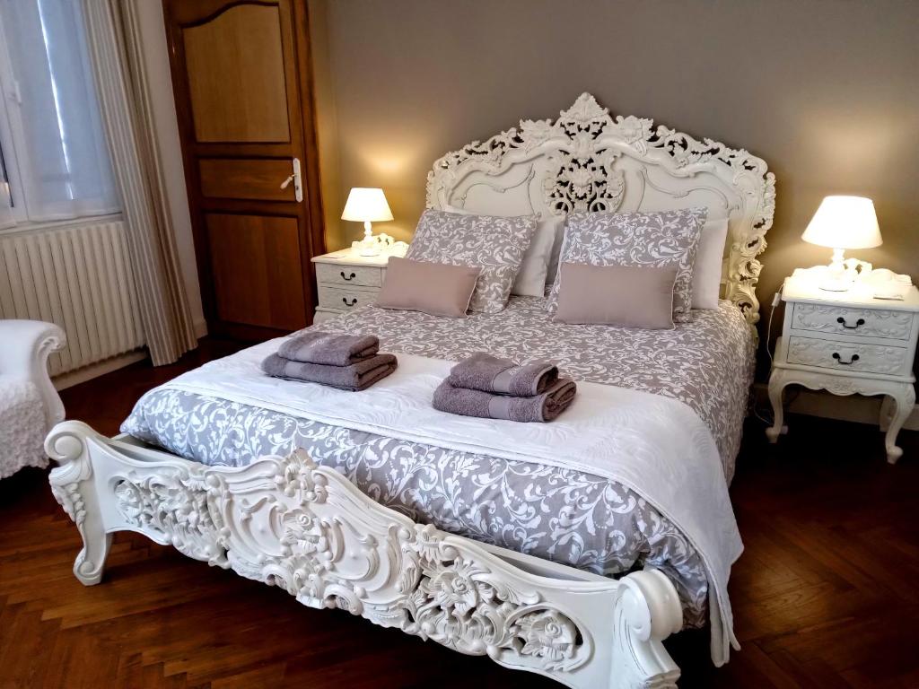 een slaapkamer met een wit bed en 2 nachtkastjes bij La Belle Vienne in Exideuil