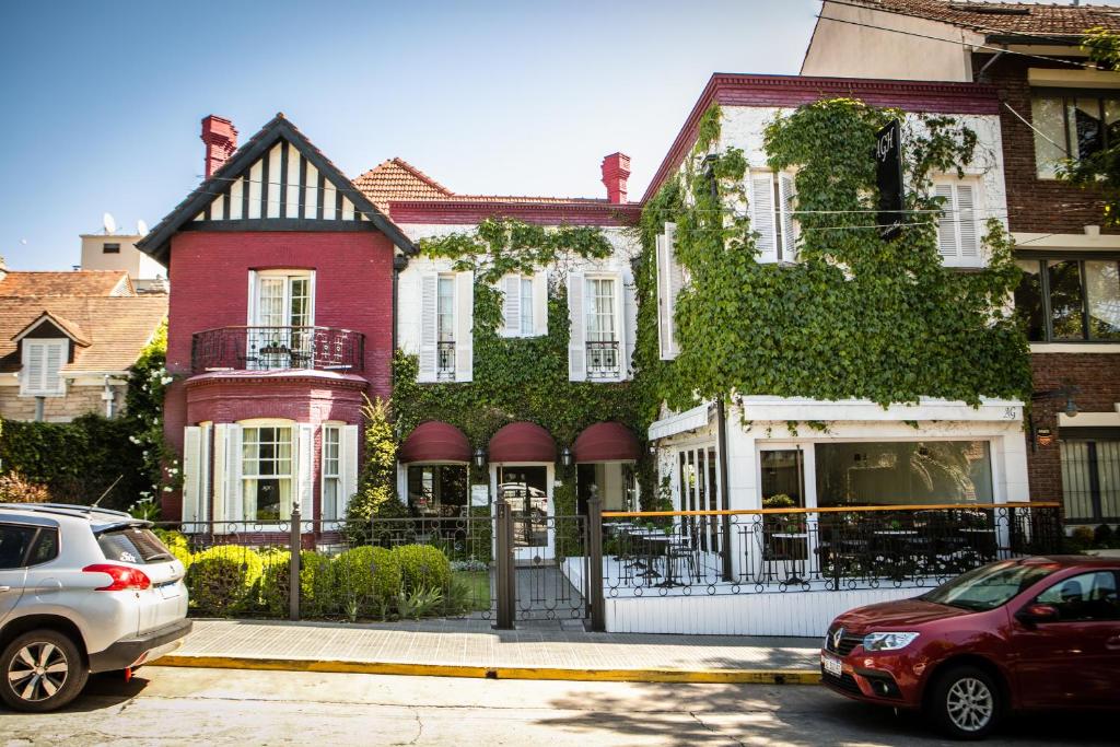 une maison avec des voitures garées devant elle dans l'établissement Altos de Guemes Hotel, à Mar del Plata