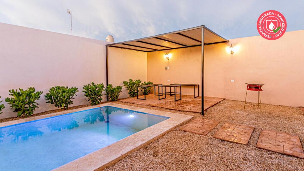 a swimming pool in the backyard of a building with a tent at Casa Familiar Sian Kaan in Caucel