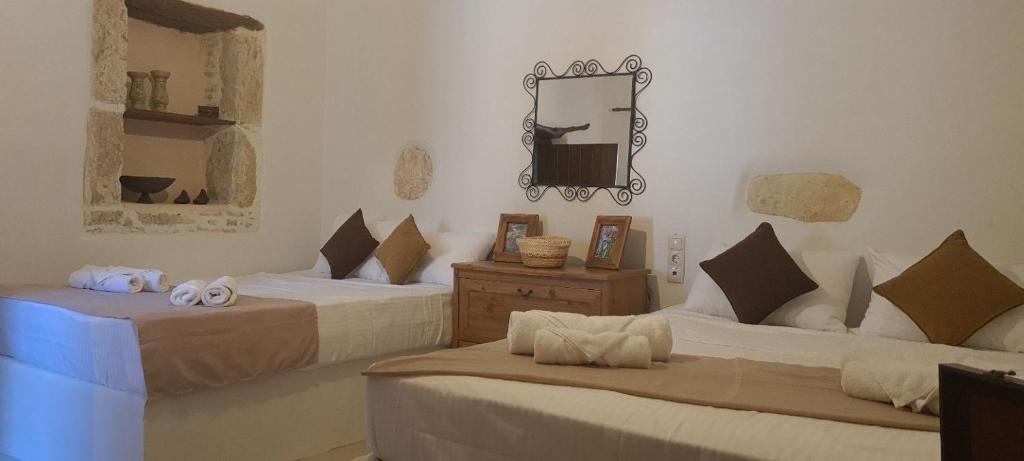 a room with two beds and a mirror on the wall at Cretan House Antonis in Kamilari