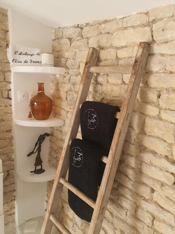 La P'tite Écurie في Saint-Jean-de-Liversay: سلم خشبي مع مناشف على جدار من الطوب