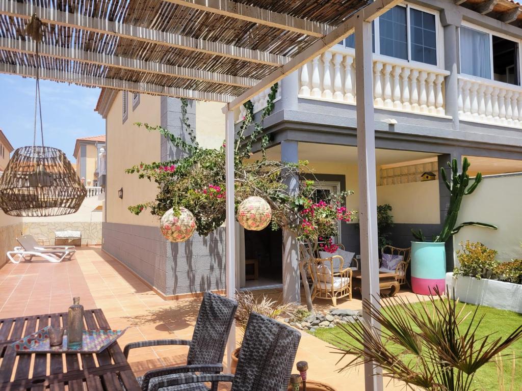 una casa y un patio con sillas y mesas. en CASA DEL MAR - Cozy Beach House, en El Médano