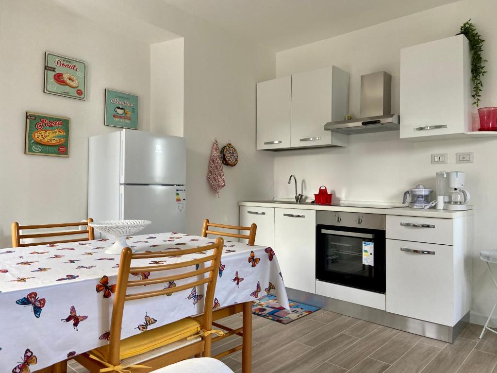 a kitchen with a table and a refrigerator at Casa Doris in Oggebbio