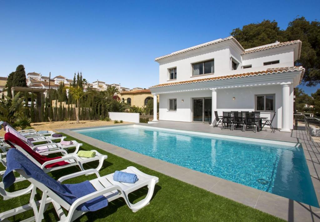 a villa with a swimming pool and lounge chairs at Villa Vallesa Calpe in Ifach