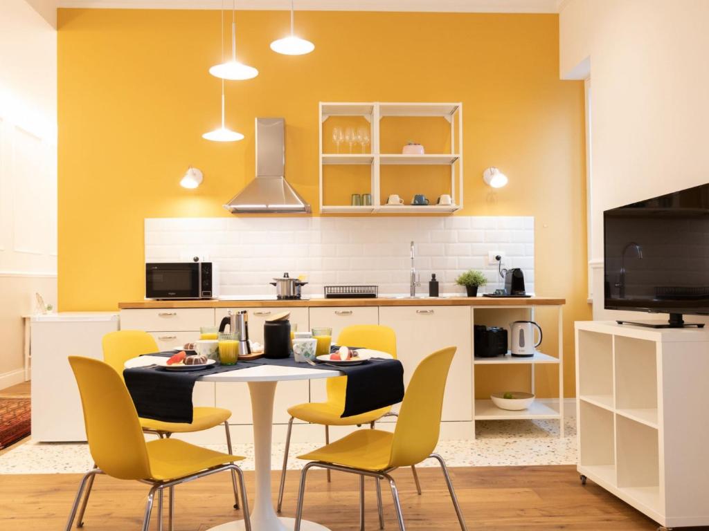 a kitchen with a table and yellow chairs at The Best Rent - Colorful one-bedroom apartment in San Giovanni district in Rome