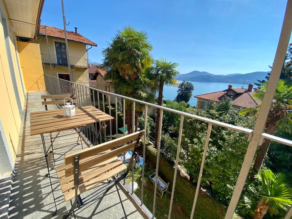 balkon z ławką i widokiem na wodę w obiekcie Casa Doris w mieście Oggebbio