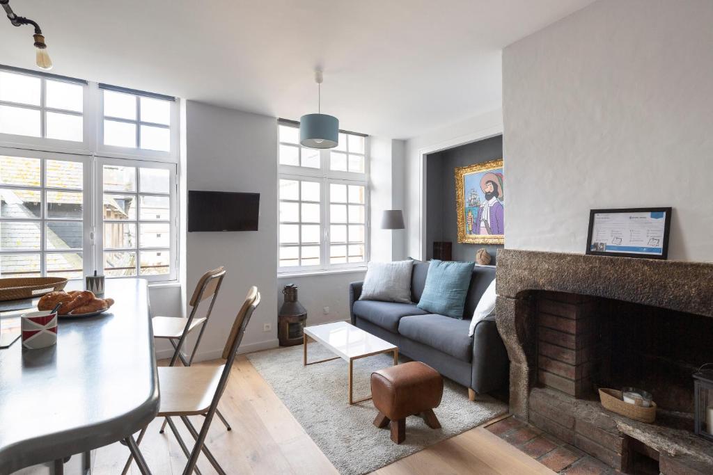ein Wohnzimmer mit einem Sofa und einem Kamin in der Unterkunft LE CORSAIRE - Petit cocon dans lIntra-Muros in Saint-Malo