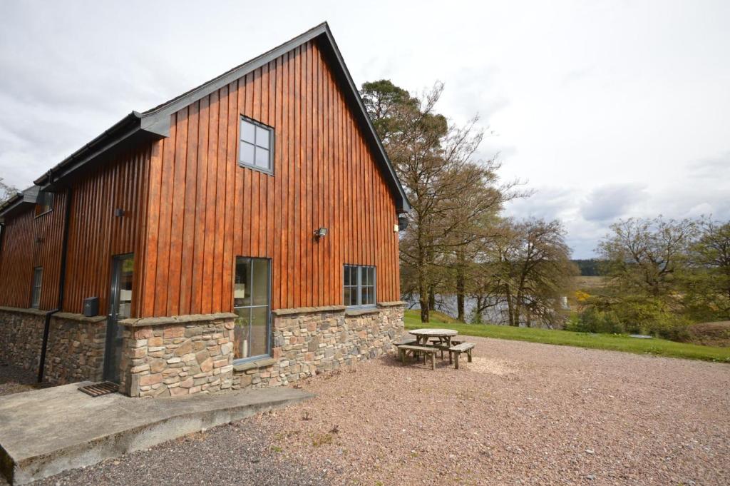 eine Scheune mit einem Picknicktisch davor in der Unterkunft Tall Pines Apartment in Spean Bridge