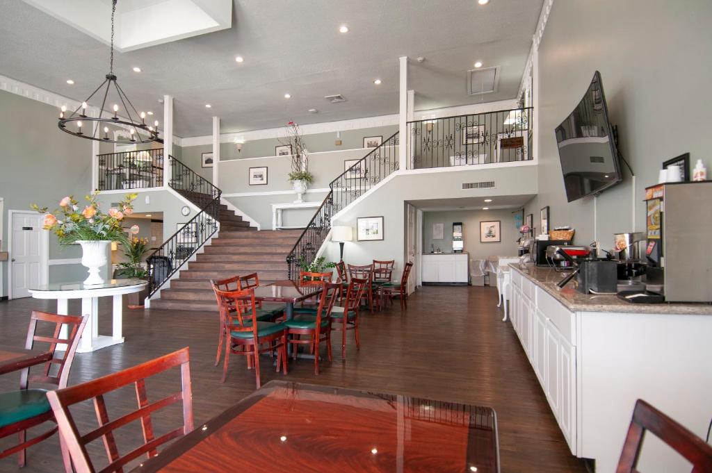 un restaurante con mesa, sillas y escaleras en Best Price Motel & Suites, en Orange